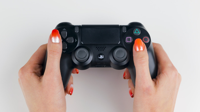 hands holding a PS4 controller