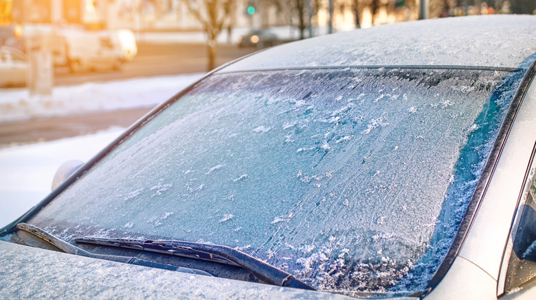 Windshield covered with ice, frozen glass and wiper