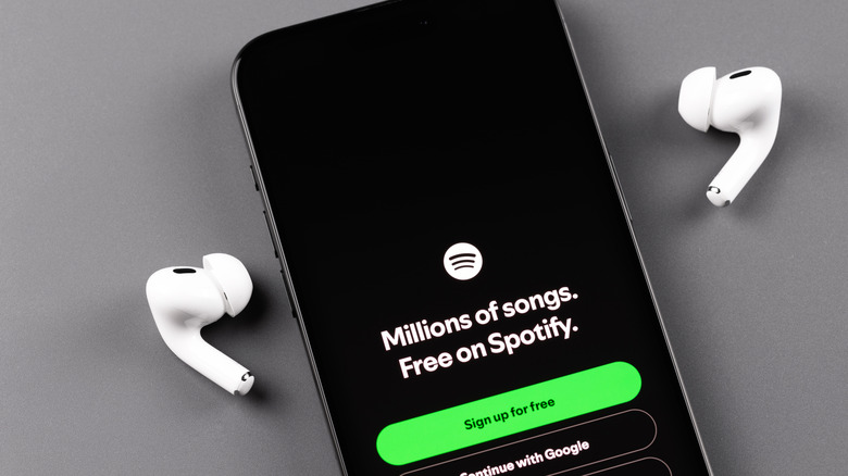 Spotify mobile app on an iPhone screen with AirPods