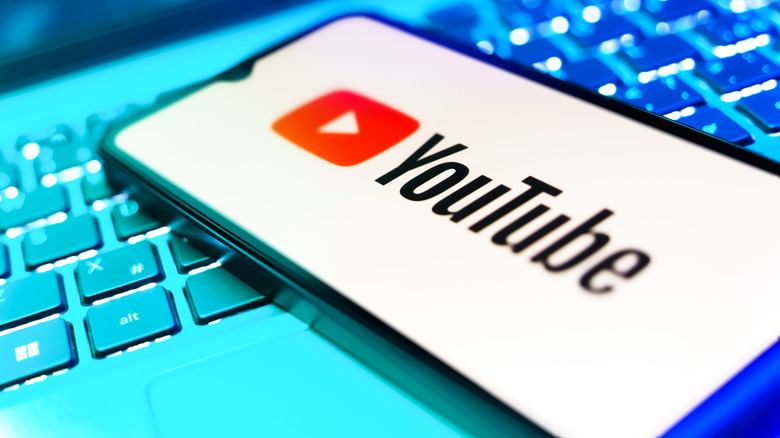 YouTube logo on a smartphone placed on a keyboard.