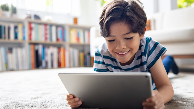 kid using a tablet smiling