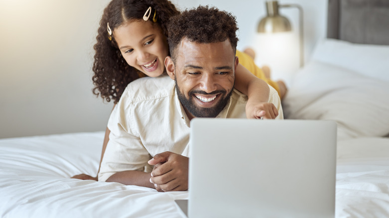 dad and kid watching laptop