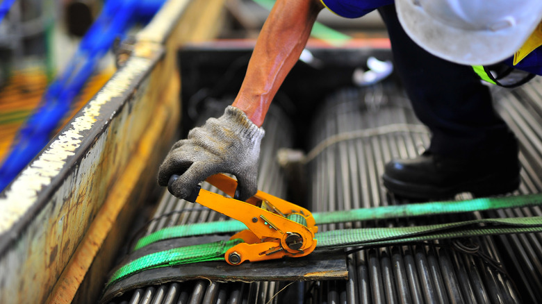 Construction worker using ratchet strap