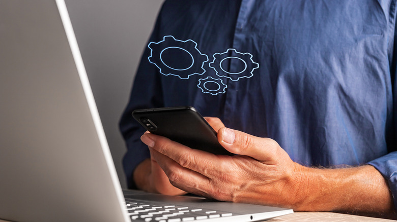 Man holding phone with virtual gears