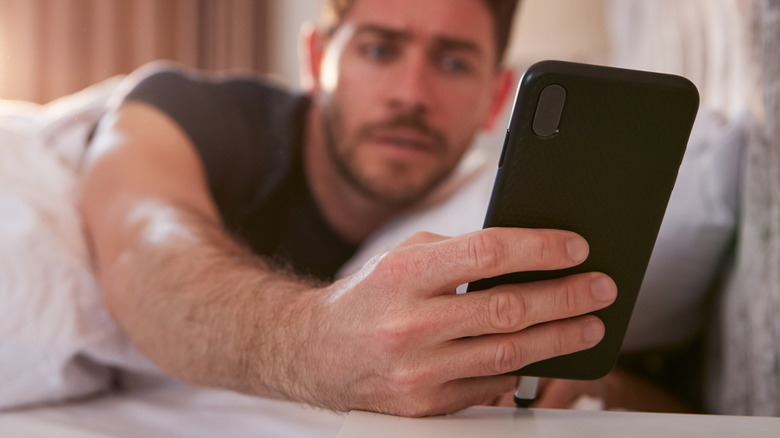 Person in bed looking at phone