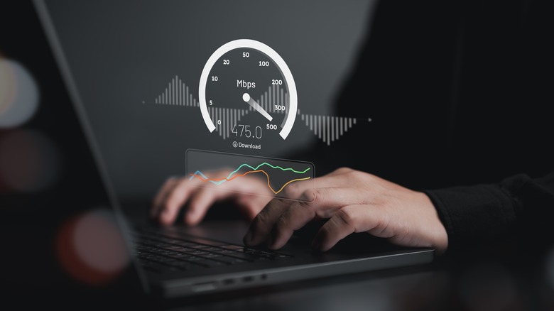 Man wearing black shirt checking internet speed on laptop