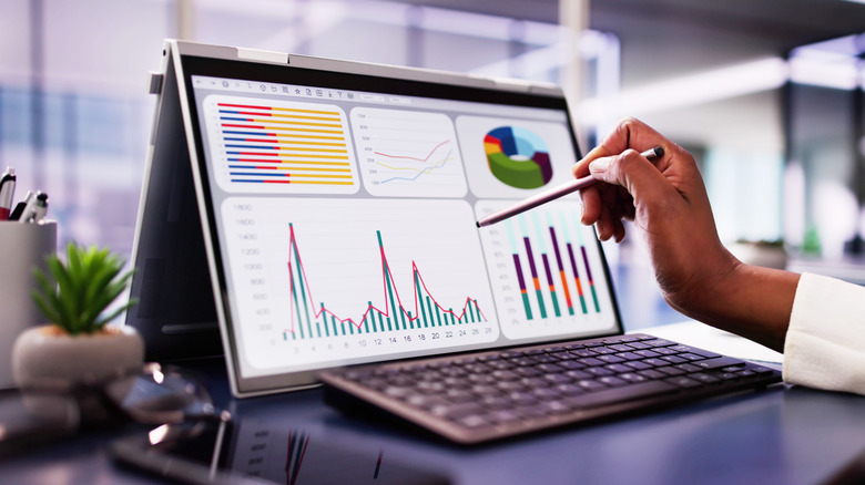 Woman analyzing financial data on laptop screen in office