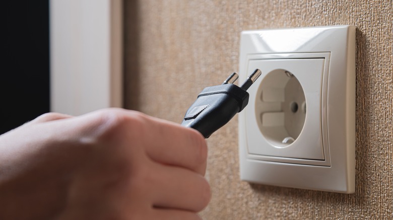 Plugging a power cord in wall socket