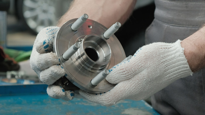 Mechanic holds a car hub bearing