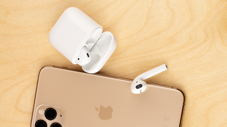 gold iPhone with opened AirPods