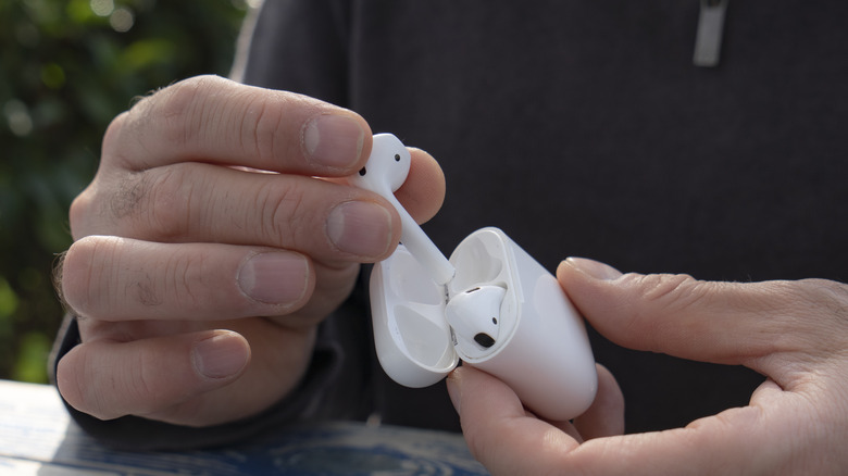 hand taking out AirPods from case