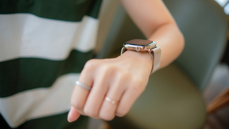 A faceless woman is wearing an Apple Watch series 10 on her wrist