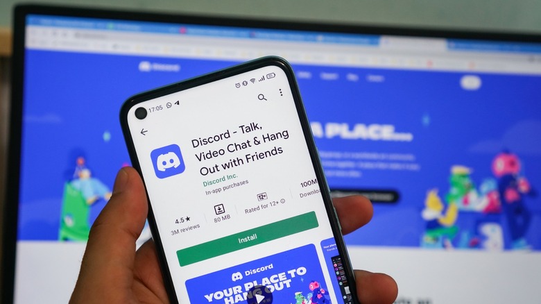 Discord app on a cell phone with the website in the background