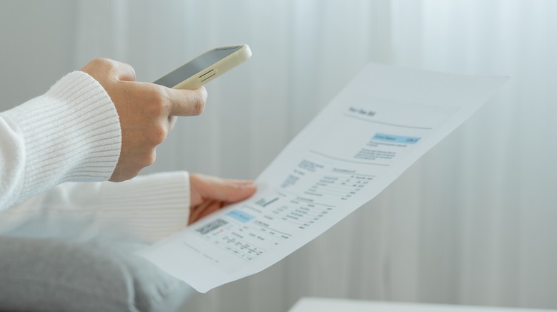 hand with phone scanning paper