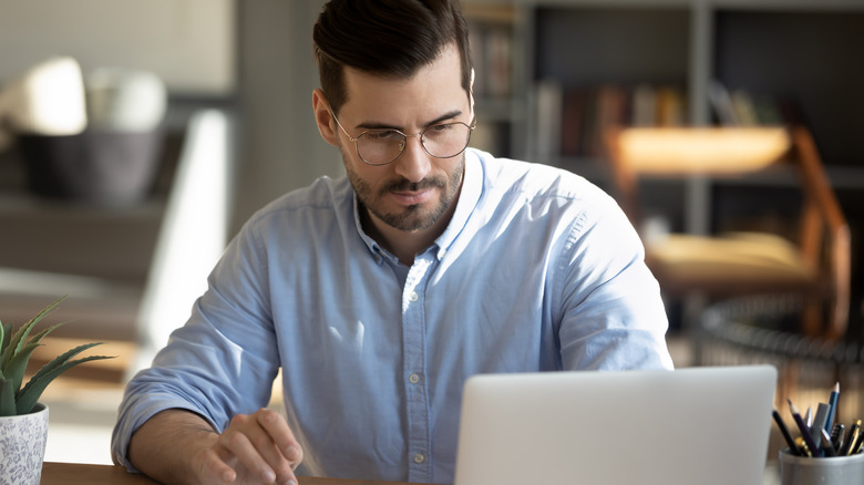 Man looks at laptop