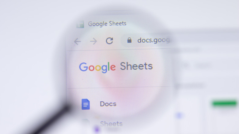 Magnifying glass hovering over Google Sheets logo on computer screen