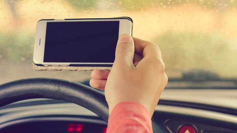 Person using iPhone while driving