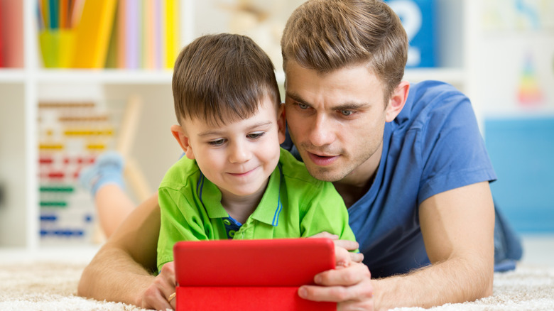 father and child using ipad
