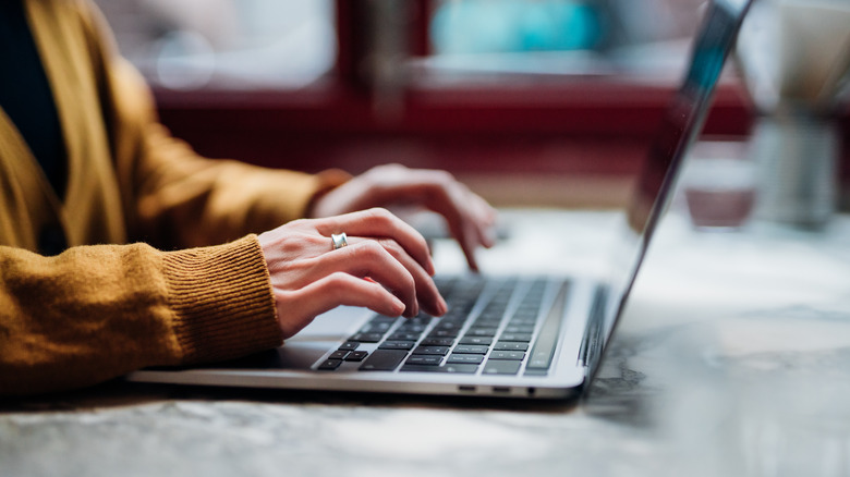 Female hand typing on laptop keyboard