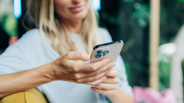 blonde woman typing on iPhone