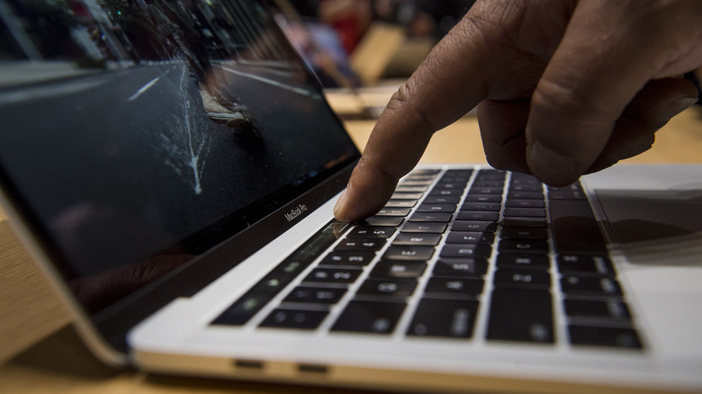 finger over MacBook Touch Bar