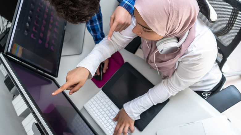 girl using MacBook with two monitors