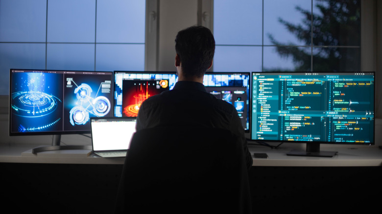 man with three monitors