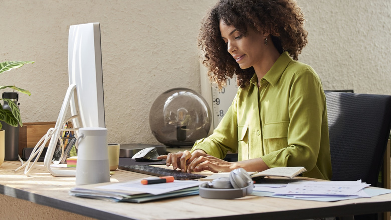 Woman in an office attire working on a computer in her workstation