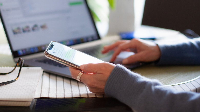 woman using phone and laptop