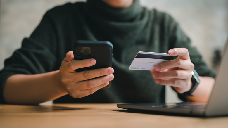 Man earning cashback from credit card and phone