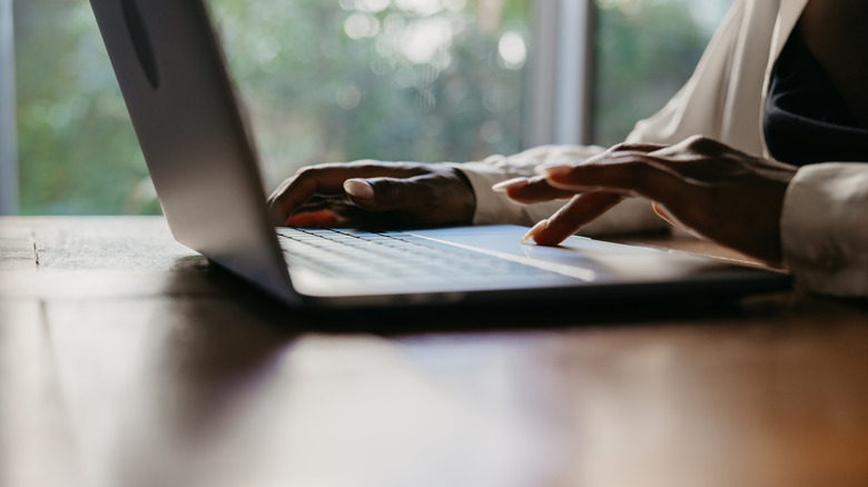 Person's hand on laptop trackpad