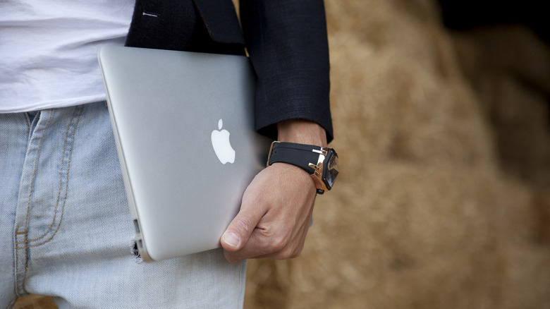 man carrying a macbook