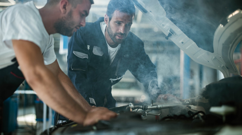 Mechanics looking at engine