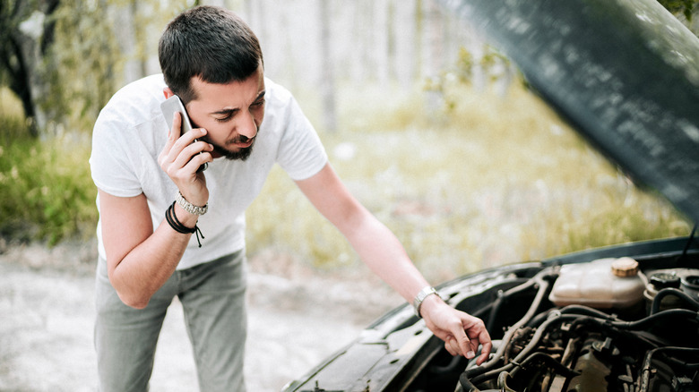 man on phone checking engine