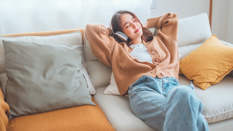 Girl listening to headphones on couch