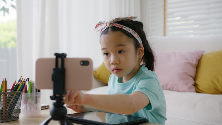 Child using smartphone tripod