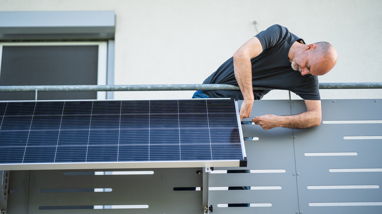 Man installing balcony solar panel