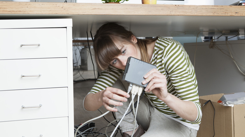 Person trying to fix Wi-Fi router