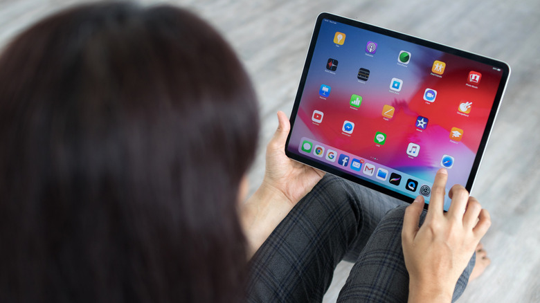 woman using iPad who is about to tap Safari