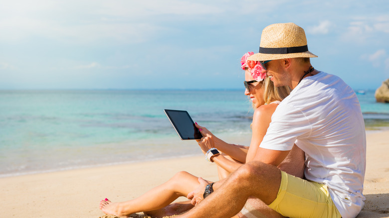 couple using iPad near water