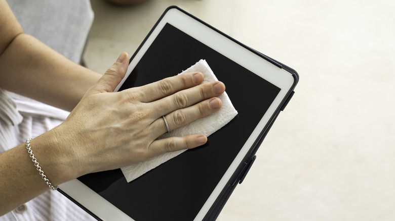 person wiping iPad screen