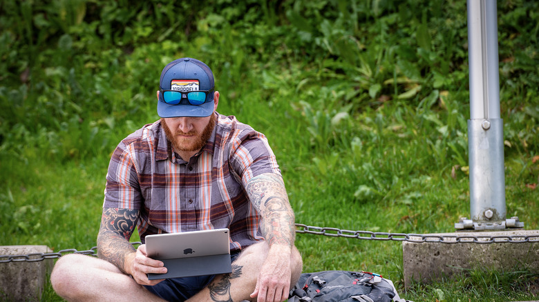 man using iPad outdoors