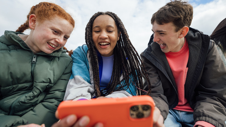 teens looking at iPhone