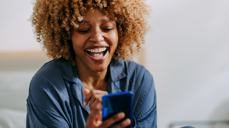 woman looking at phone laughing