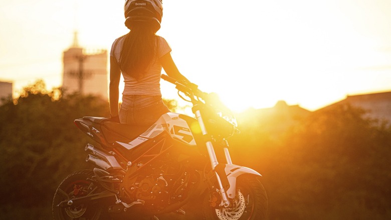 Benelli TNT 135 and rider posing at sunset