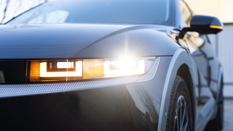 A close-up of a car headlight with the blinker on