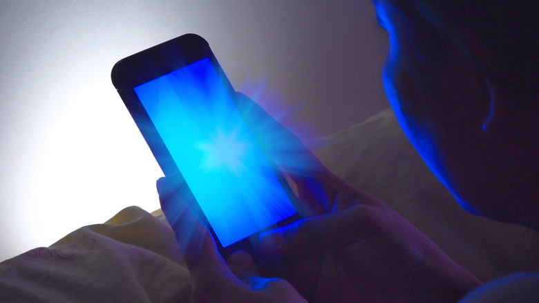 Woman using phone with blue light
