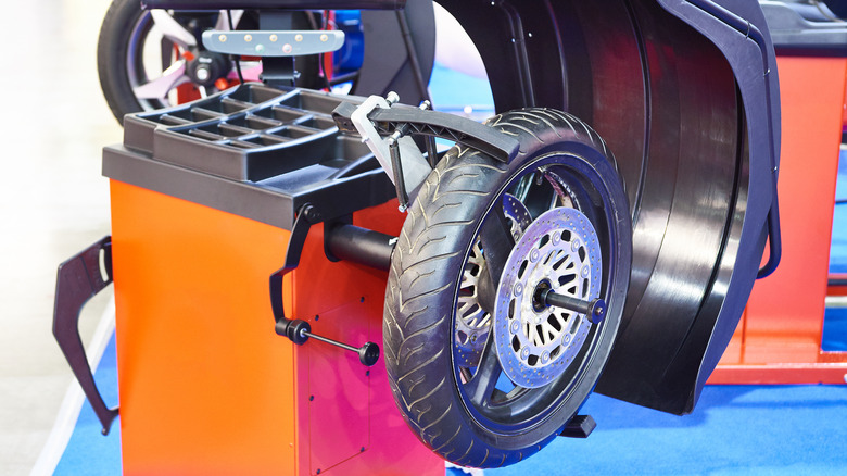 A Motorcycle Wheel Mounted To A Dynamic Balancing Tool