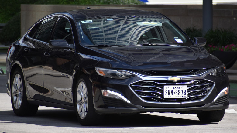 A black Chevrolet Malibu cruising on the road