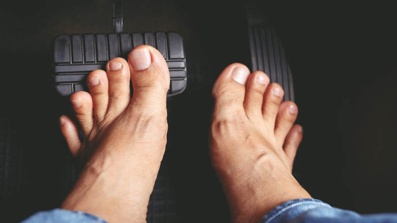 Person barefoot pressing break and gas pedals